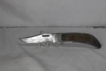 S&W folding hunter with 3.75 inch blade. Stainless steel handle with inserts. Has some etching on