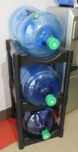 group of 3 empty water bottles and a rack