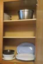 dishes and mixing bowls in kitchen cabinet