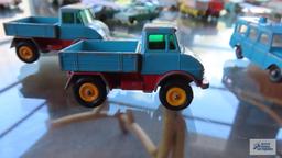 Two red and teal trucks made in England by Lesney, one missing rubber tires