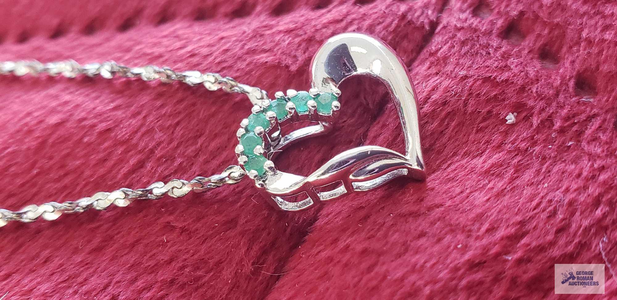 Silver colored heart-shaped pendant with green gemstones, marked 925, on silver colored twist