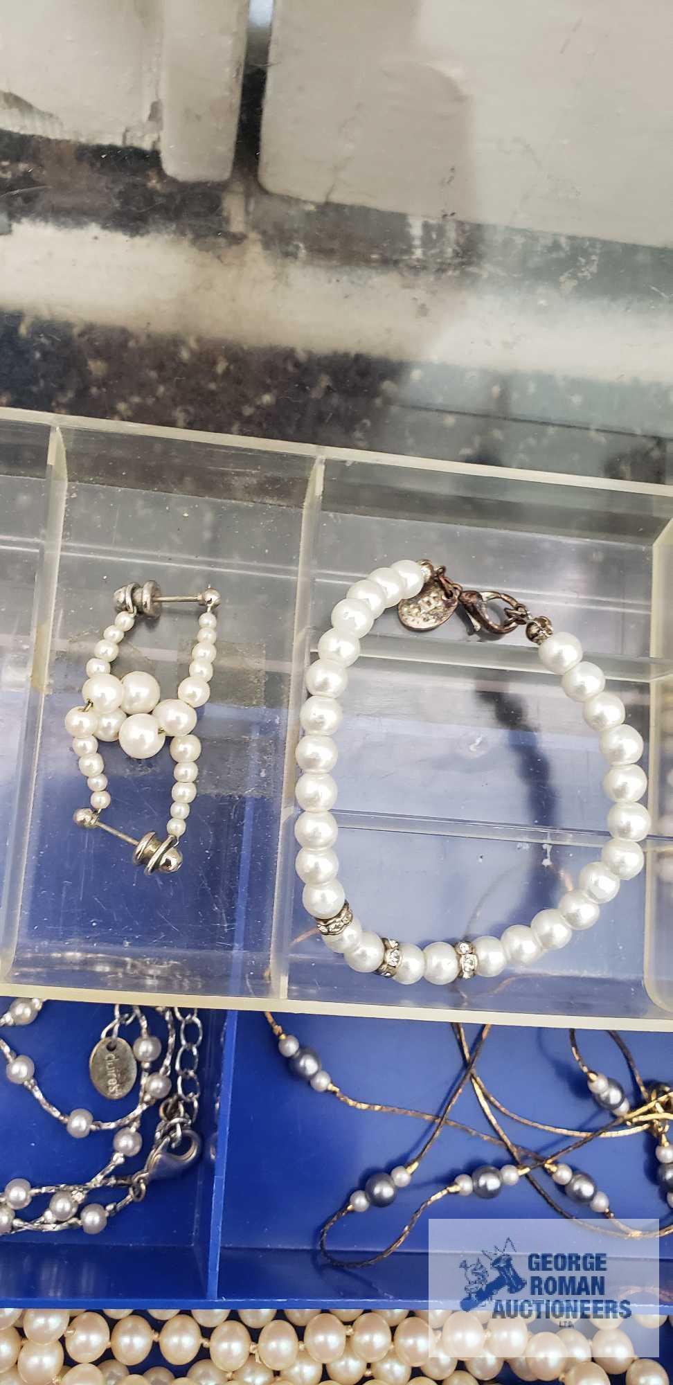 Pearl like costume jewelry in clear plastic divided container