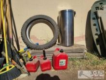 Gas Cans, Motorcycle Wheel and Tire, and Trash Can