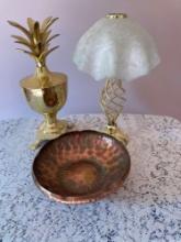 Brass pineapple container, lamp candleholder with frosted shade, and copper bowl