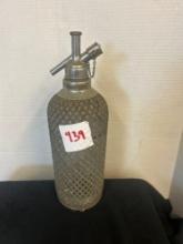 vintage soda seltzer bottle with metal mesh