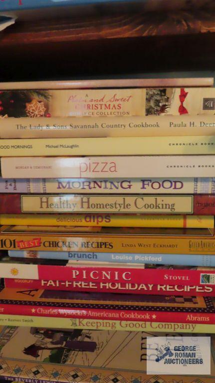 Three shelves of various books including recipe books, children's books, folk art magazine books,